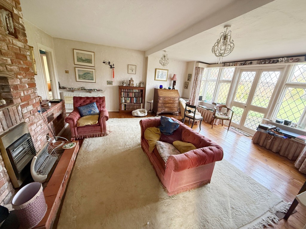Lot: 155 - DETACHED BUNGALOW FOR IMPROVEMENT IN POPULAR LOCATION - Living room with fireplace and French doors to garden